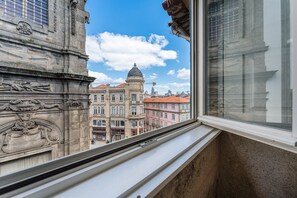 Blick aus einem Fenster auf ein historisches Gebäude mit aufwendiger Steinarchitektur und einer Kuppel.