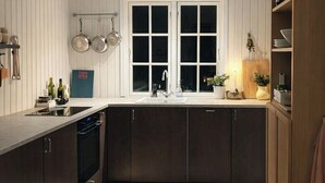 A modern kitchen with a central island, a double sink, and a large window. - Little oasis with large terrace and a cozy garden (Grevinge)