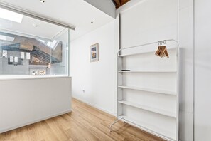 Ein modernes Interieur mit einer Glaswand, einem weißen Regalelement und einem gerahmten Bild an der Wand.