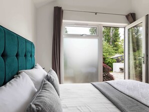 Ein Schlafzimmer mit einem Bett, einem Fenster und Blick ins Freie.