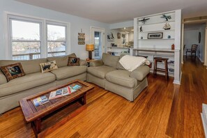 Ein Wohnzimmer mit Ecksofa, Couchtisch und Bücherregal.