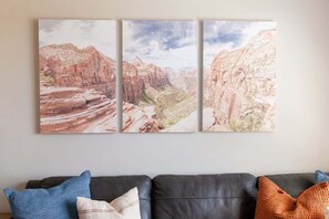 Eine Wand mit einem dreiteiligen Landschaftsgemälde.