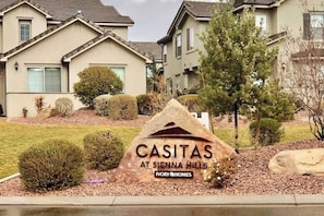 Ein Wohngebiet mit Häusern, einem Schild für Casitas at Siena Hills und dem Logo von Ivory Homes.