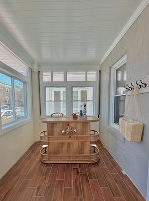 A corner room with a wooden table, chairs, and a window with a view of parked cars. - Atlantic Tides Coastal Escape – Steps to Beach & Casinos (Atlantic City)
