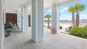 A covered outdoor area with a view of the beach, a wooden bench, and a table. - Sea Haven (Navarre)