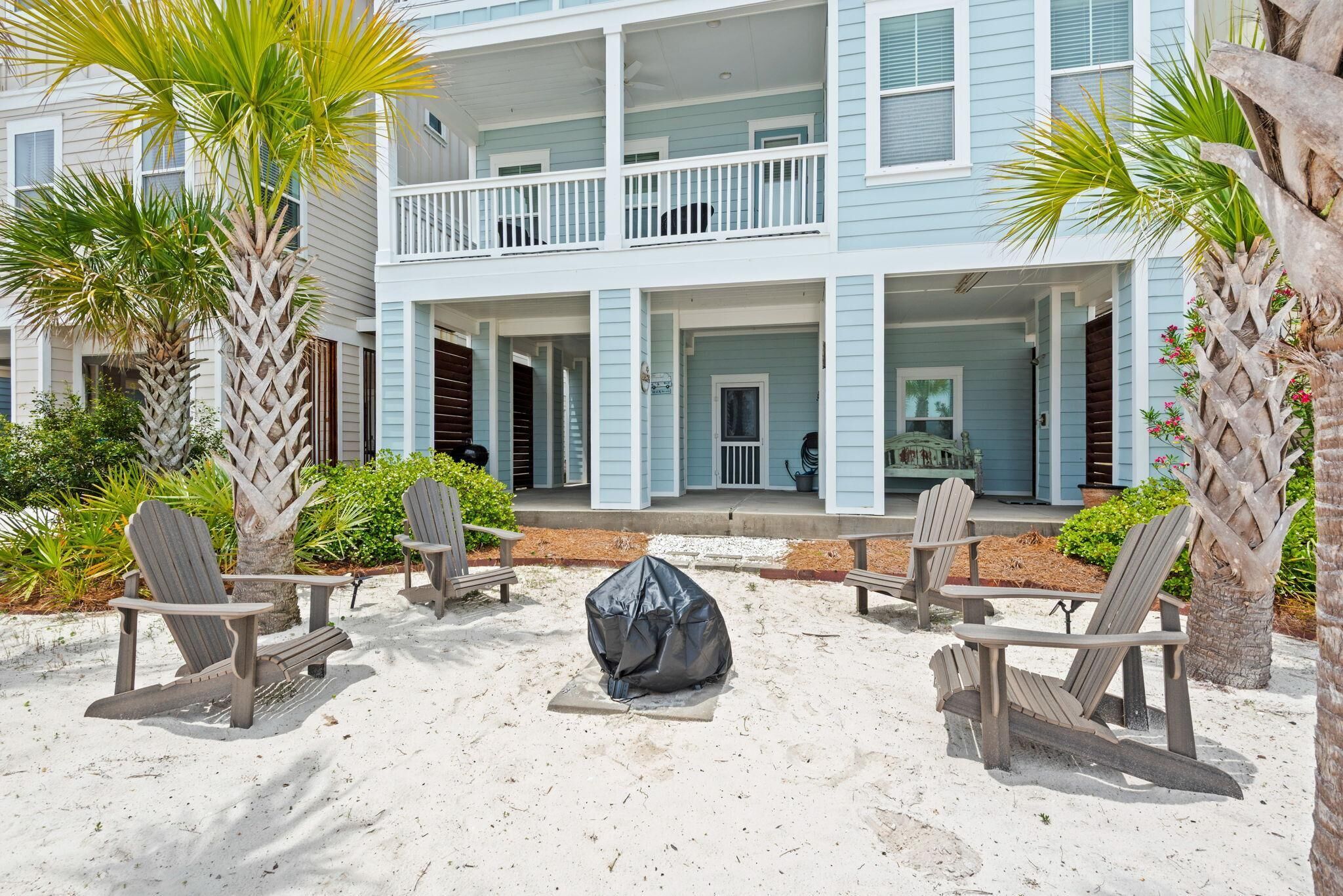 A beachfront property with a covered seating area, a covered fire pit, and a two-story building with balconies.