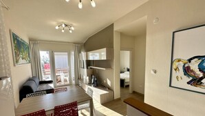 Ett modernt hotellrum med en matplats, en TV och en balkong med utsikt.