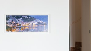 Une photographie encadrée représentant une ville côtière de nuit, avec des bâtiments et des bateaux.