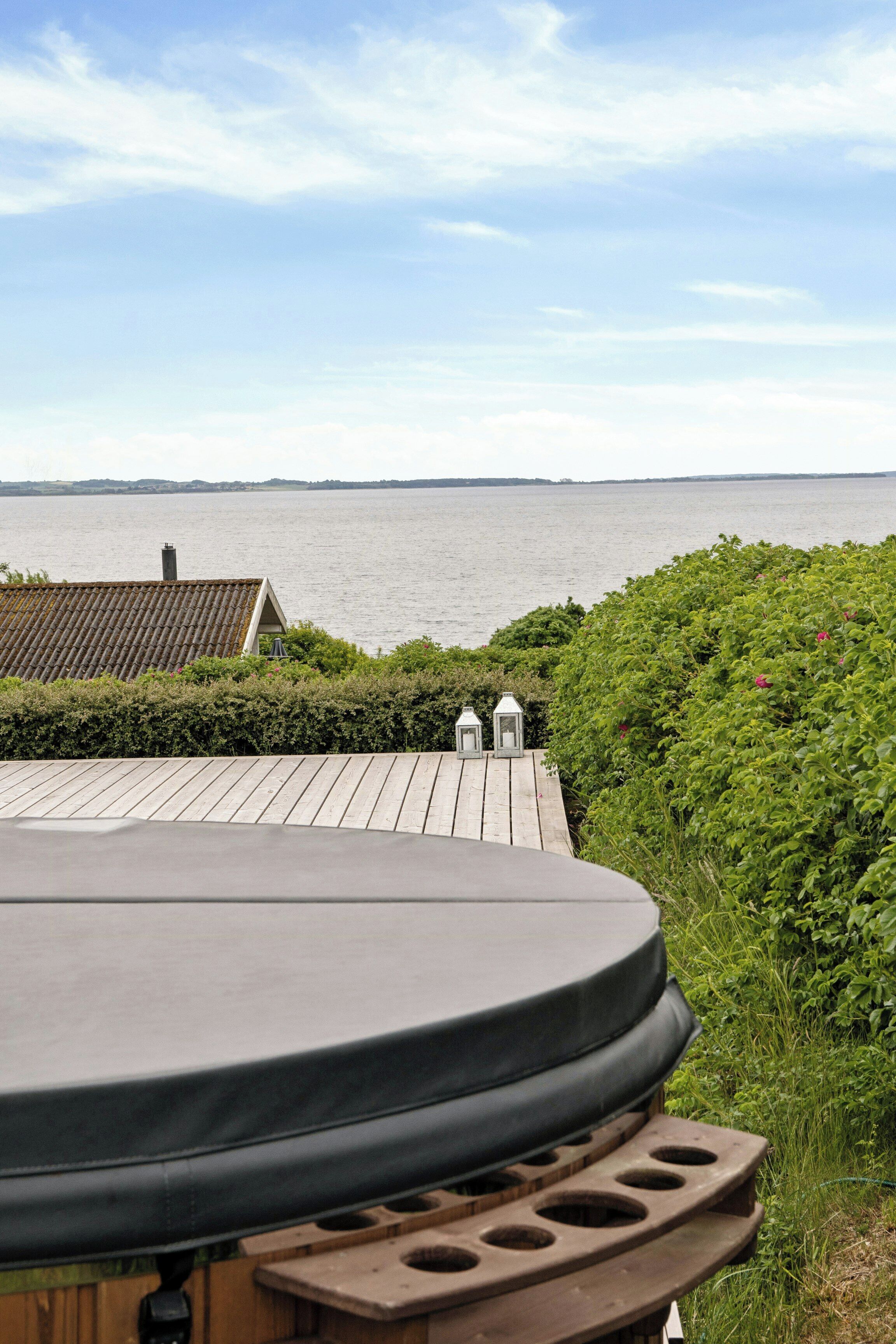 A hot tub with a view of the water and distant land.