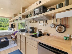 Eine moderne Küche mit Einbau-Mikrowelle, Wasserkocher und Kaffeemaschine.