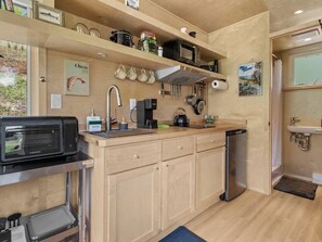 Cocina compacta con microondas integrado, cafetera y lavabo.
