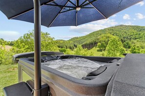Un bain à remous avec vue sur une colline boisée.
