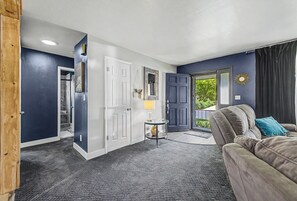Ein Wohnzimmer mit grauem Teppich und grauem Sofa.