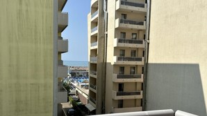 A high-rise building with multiple balconies, a view of a beach, and a clear sky. - Comfortable Stay in a Great Area (San Michele al Tagliamento)