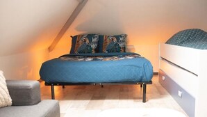 A bedroom with a bed, a bedside table, a dresser, and a sofa. - CENTRAL 55m2 - 4 PERSONNES - COSY - PROCHE NAUSICAA (Boulogne-sur-Mer)