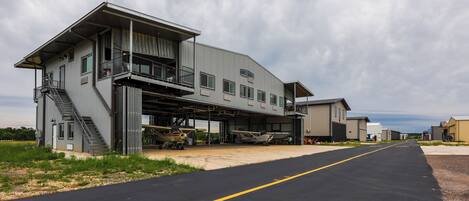 A large industrial building with a covered loading dock and a staircase leading to a second floor.
