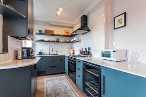 Een moderne keuken met een magnetron, oven en spoelbak.