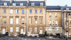 A row of traditional terraced houses with uniform window designs and a central entrance. - The Paragon Abode Bath Central Period Apartment (Bath)