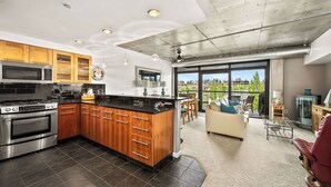 Une cuisine moderne dotée d’un îlot central, d’appareils électroménagers en acier inoxydable et d’armoires en bois.