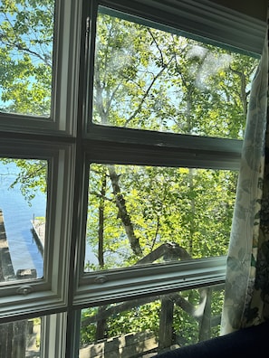 Ein Fenster mit Blick auf einen See und Bäume.