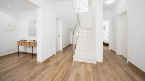 A spacious hallway with a wooden floor, white walls, and a staircase leading to another room. - Villa Yaiza Secret 2 (Yaiza)