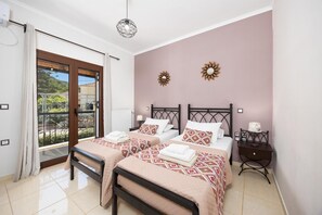 Ein Schlafzimmer mit zwei Betten, einem Balkon, einer Deckenleuchte und einer Wanddekoration.