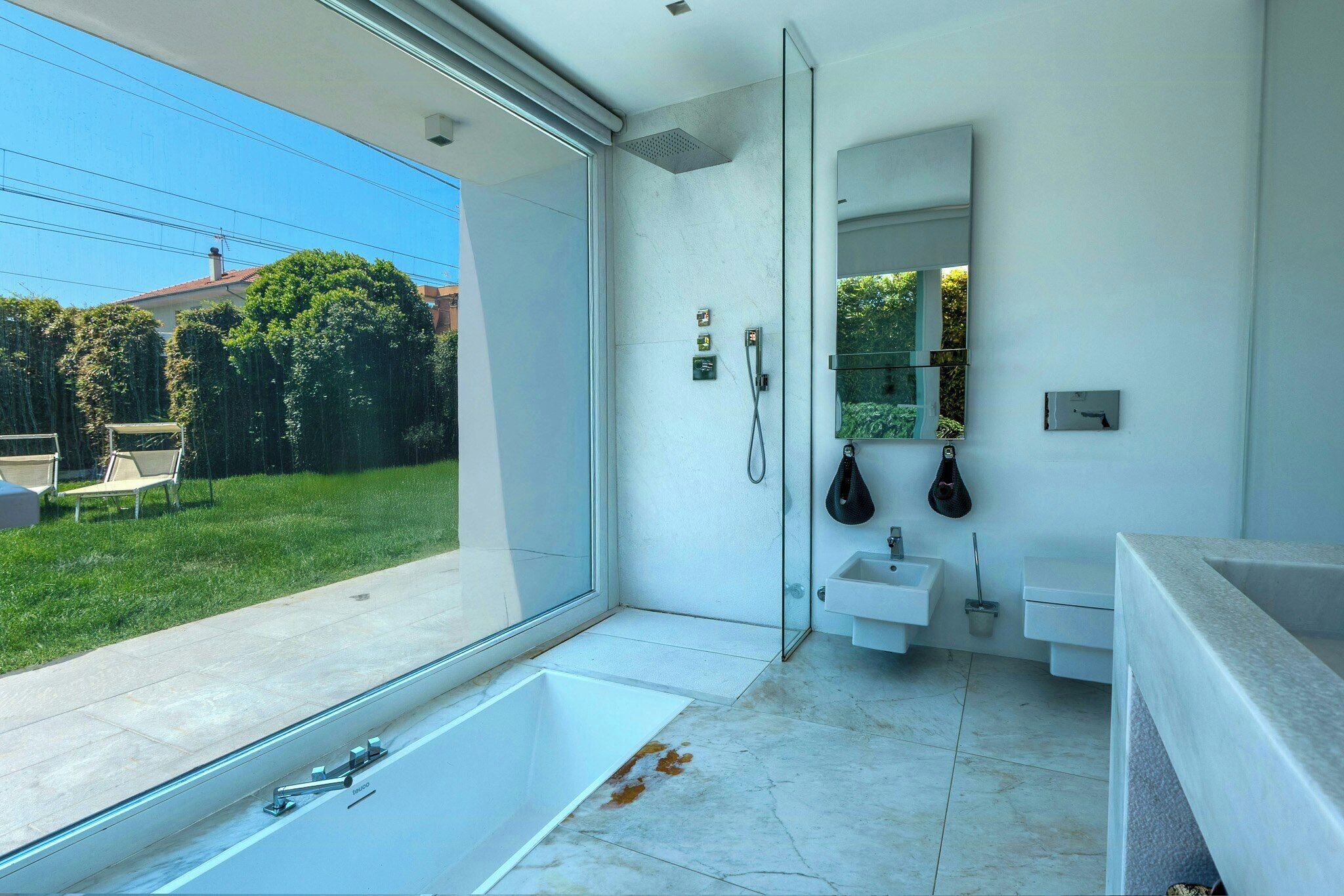 Ein modernes Badezimmer mit einer großen Badewanne, einer Glasdusche und einem Waschbecken.