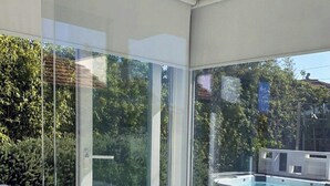 A modern interior with large glass doors leading to an outdoor area, a pool, and a patio with a barbecue. - Beachfront villa with jacuzzi in Senigallia (Marzocca)