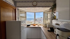 A kitchen with a view of the sea, a clock, and a modern design. - Albufeira Amazing View 2 by Homing (Albufeira)