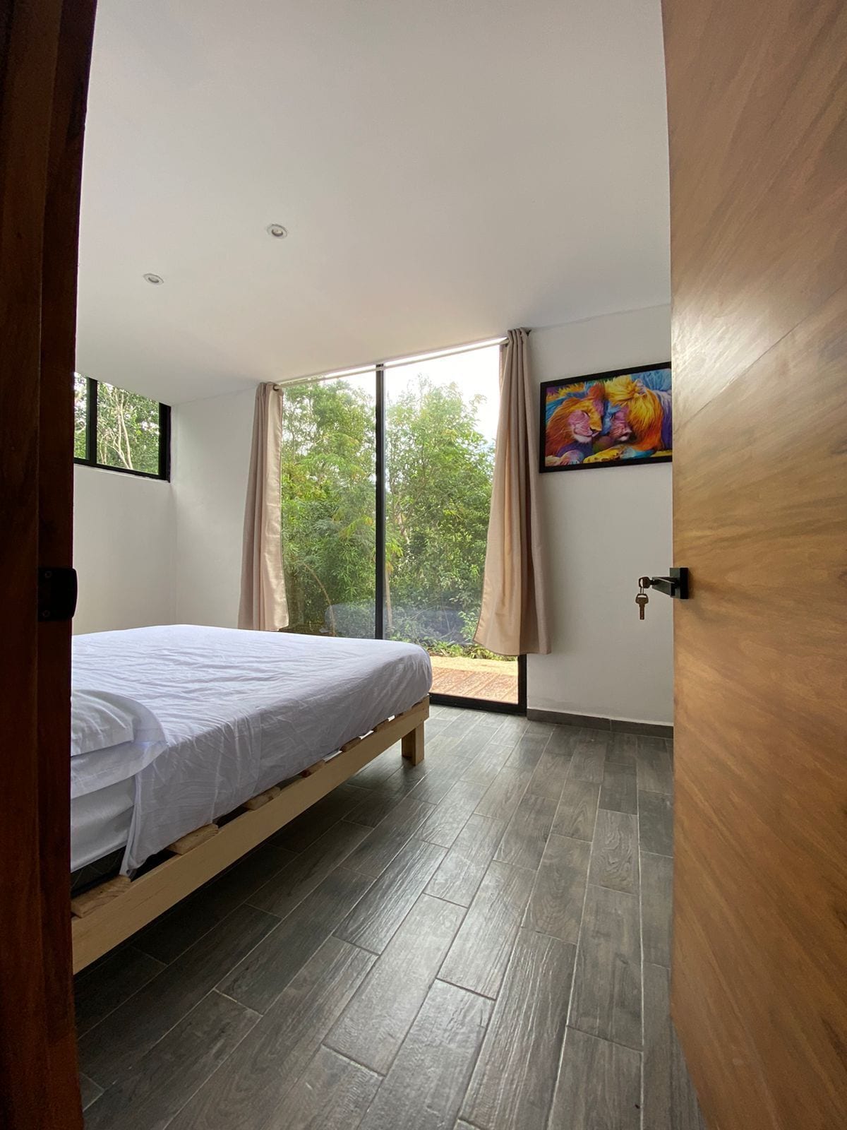 Un dormitorio con cama, ventana y puerta.