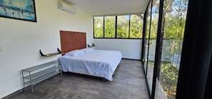 A bedroom with a bed, a window, a painting, and a balcony. - Cuatro Elementos Noh By GEstores (Tulum)