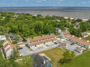 A residential area with a row of houses, a parking lot, and a view of the ocean.