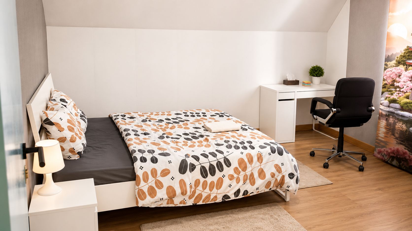 A bedroom with a bed, a desk, a chair, and a nightstand.