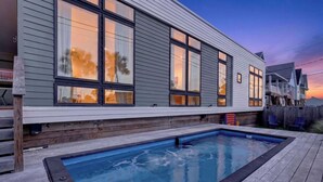 A modern house with a swimming pool, large windows, and a deck. - Resting Beach Face | Private Pool • Modern Coastal Retreat • Prime 11th St Location (Port Aransas)