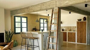 Une cuisine spacieuse dotée d’un îlot central, de meubles en bois et d’un plafond en béton.