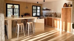 Une cuisine avec un coin bar, des meubles en bois et une grande fenêtre.