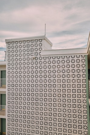 A building facade with a geometric lattice pattern. - Hotel Margot (Pensacola)