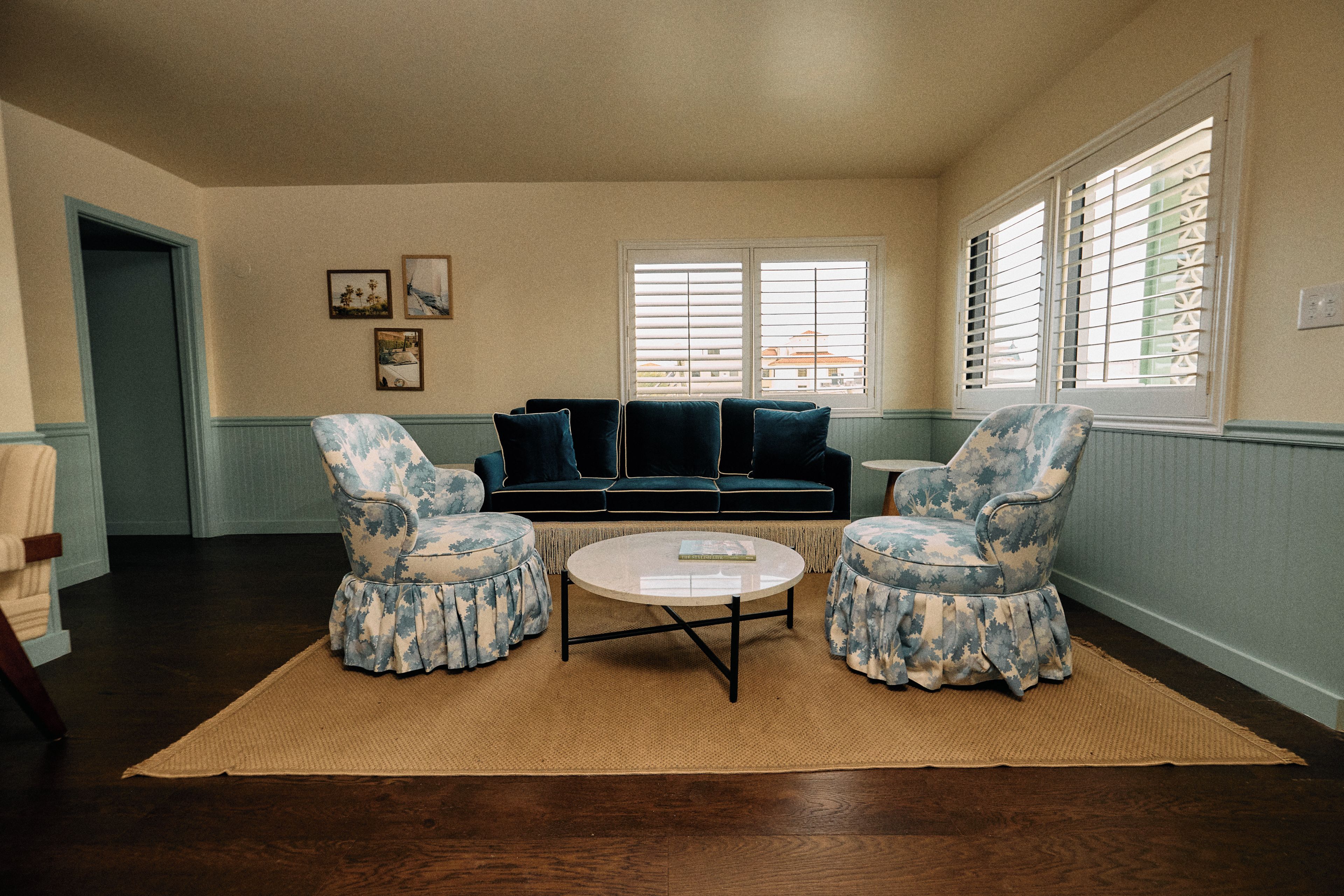 A living room with a sofa, two armchairs, a coffee table, and a rug.