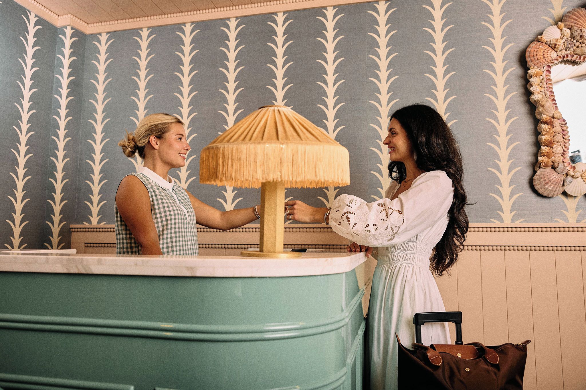 A reception area with a counter, a lamp, and a mirror on the wall.