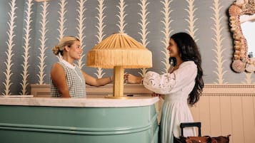 A reception area with a counter, a lamp, and a mirror on the wall.