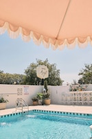 A swimming pool with a sign that reads 'HOTEL Margot' and a 'NO DIVING' sign.