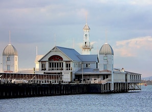 Un bâtiment situé au bord de l’eau, doté de deux structures en forme de dôme, d’une tour centrale et d’une enseigne indiquant le nom « Curry’s ».