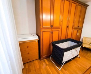 A room with wooden cabinets, a white appliance, and a polka-dotted baby play area. - Between Prosecco Hills and Venice-Casa Il Sogno (Cal Grande)
