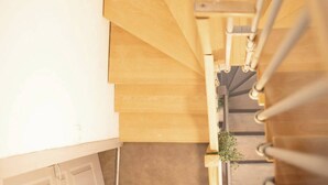Un escalier en bois avec une rampe, menant à un niveau inférieur.