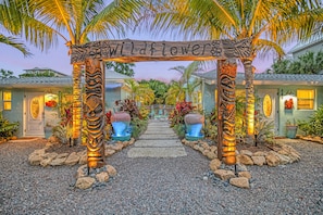 A pathway leading to a building with a sign reading 'wildflower.' - New Listing - Dates Available Now!  Beach & Village | Pool | Dock | Game Room! (Siesta Key)