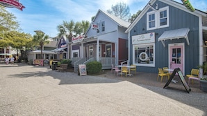 A street with buildings, including a food and oyster house, a pizza place, and a cafe. - My Magnolia @ Magnolia Bay (Miramar Beach)