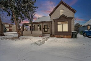 A two-story house with a front porch, a garage, and a driveway.