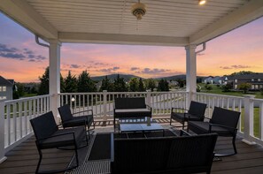 Eine überdachte Terrasse im Freien mit Blick auf eine Wohngegend bei Sonnenuntergang.