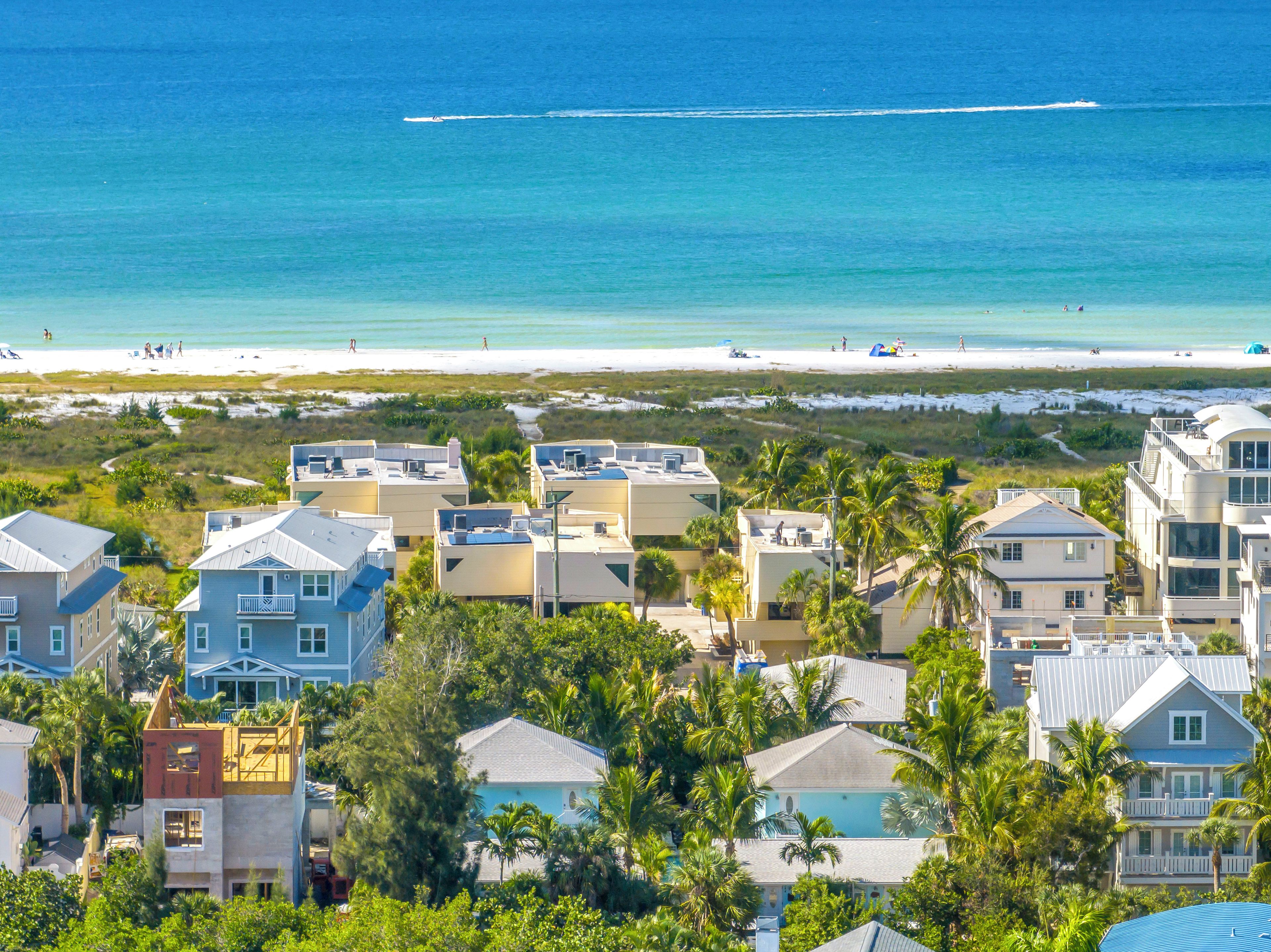 A coastal residential area with beachfront properties, including houses with balconies and a view of the ocean.