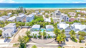A coastal residential area with houses, a swimming pool, and a beach in the background. - Walk to Siesta Key Beach & Village | Pool | Dock | Game Room! (Siesta Key)